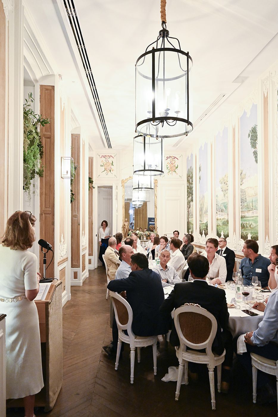 Grandes lanternes suspendues au-dessus de la table du dîner, salle vue dans sa longueur